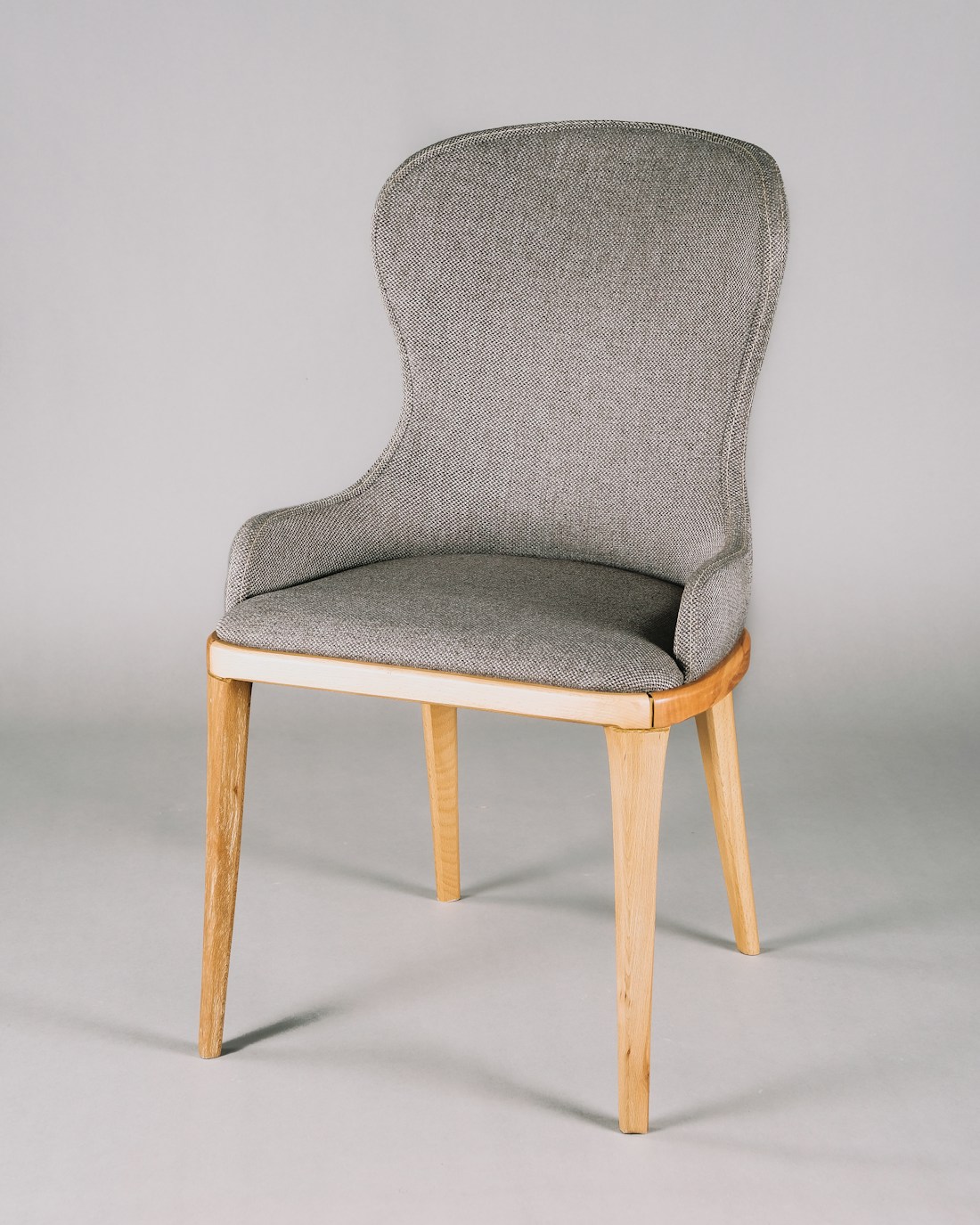 Textured grey upholstered chair on a light wooden frame